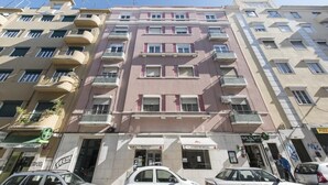 Un edificio de varios pisos con balcones, una farmacia y un restaurante.