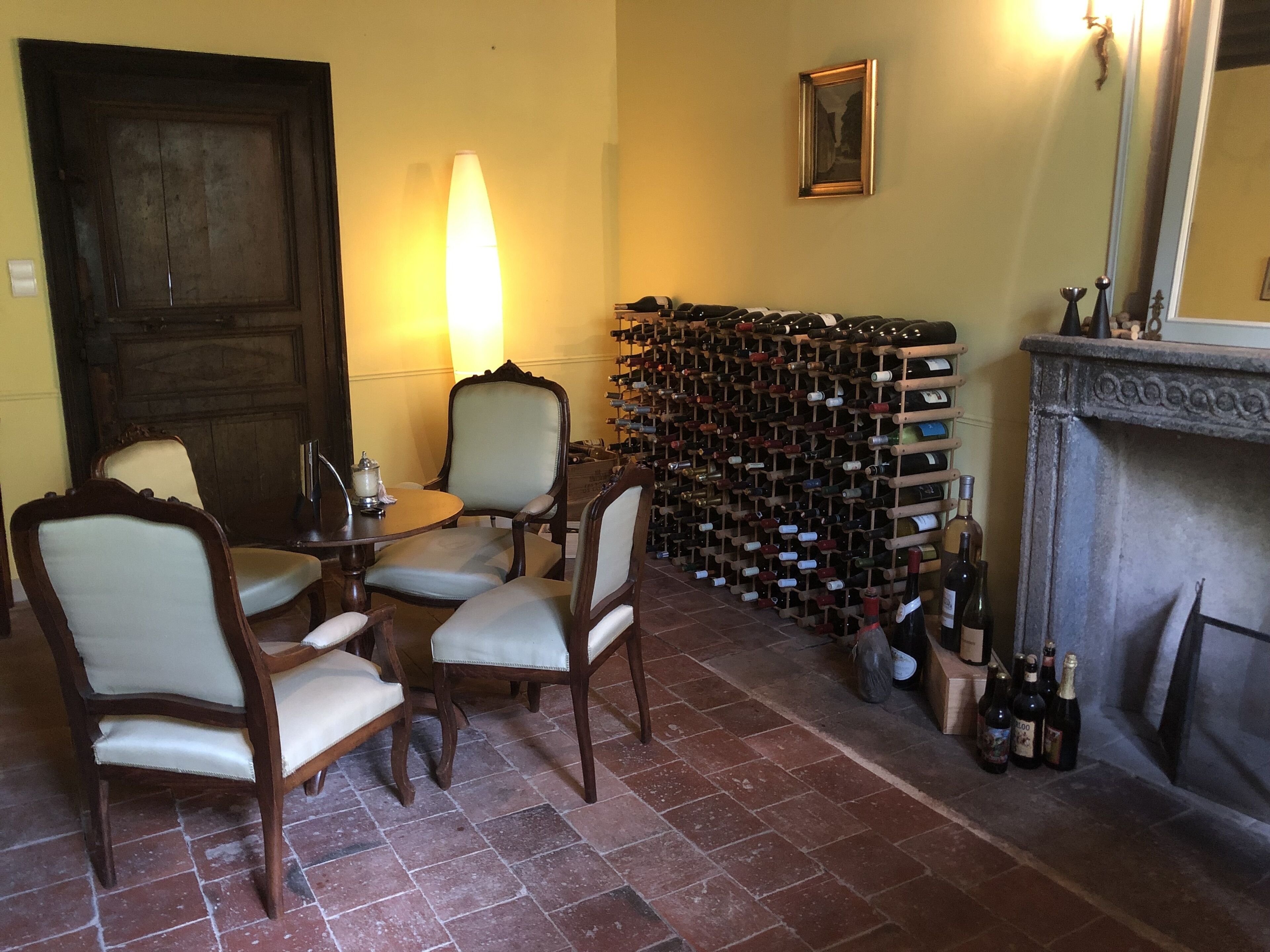 Quarto com adega, lareira e espaço de refeições com cadeiras e mesa.