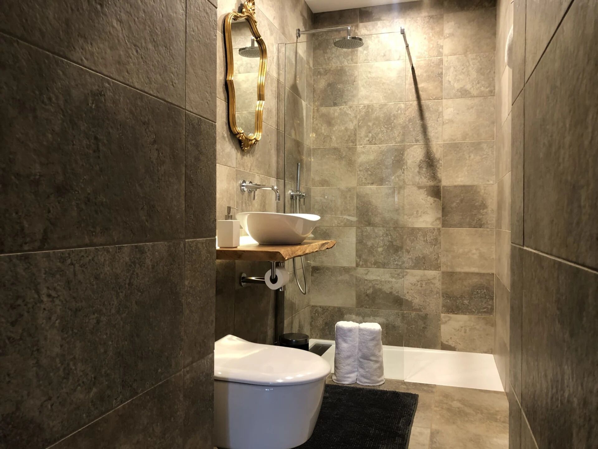 Un baño moderno con inodoro, lavamanos y ducha.