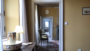 Un couloir avec une table et des chaises, une lampe et une cheminée.