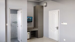 A room with a desk, wardrobe, and a door. - The 1998 Homestay (Aizawl)