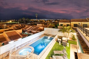 A rooftop swimming pool with a hot tub, surrounded by lounge chairs and palm trees, overlooking a residential area at night. - Villa Dalara Maspalomas, private Pool and Jacuzzi (San Bartolomé de Tirajana)