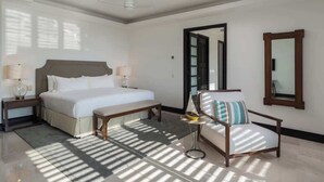 A hotel room with a bed, bedside tables, a chair, a small table with a bowl, a mirror, and a ceiling fan. - Hacienda de Mita Golf View Beach Clubs & Golf Cart (Punta de Mita)