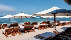 A beachside lounge area with sun loungers and umbrellas, overlooking the ocean. - Hacienda de Mita Golf View Beach Clubs & Golf Cart (Punta de Mita)