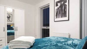 Une chambre à coucher avec un lit, une armoire, un radiateur et une fenêtre avec des stores.