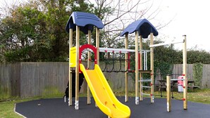 A playground with a yellow slide, climbing structures, and overhead shelters. - The Spice Ship (Weymouth)