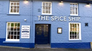 A building with a sign reading "THE SPICE SHIP" and a welcome sign for a restaurant, accommodation, and live sports. - The Spice Ship (Weymouth)