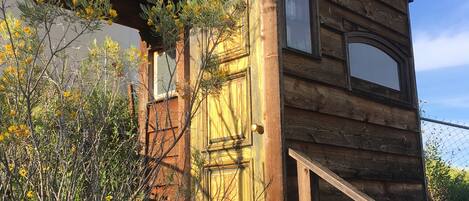 A wooden cabin with a wooden door and a small window.