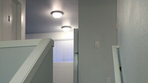 A staircase with wooden steps and white walls. - Rainier Guesthouse (Walk to Metro) (Seattle)