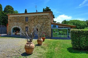 A stone building with a glass conservatory and potted plants in the foreground. - Fienile - Apartment with pool (Montaione)