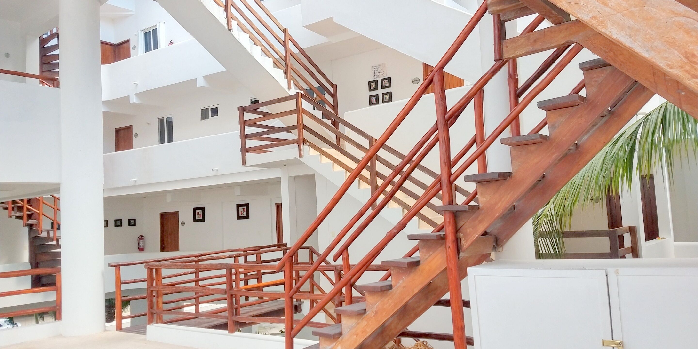 A multi-level interior with wooden staircases and white walls.