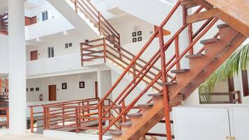 A multi-level interior with wooden staircases and white walls.