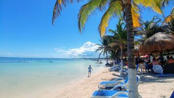 Sur la plage, chaise longue, parasol, serviettes de plage