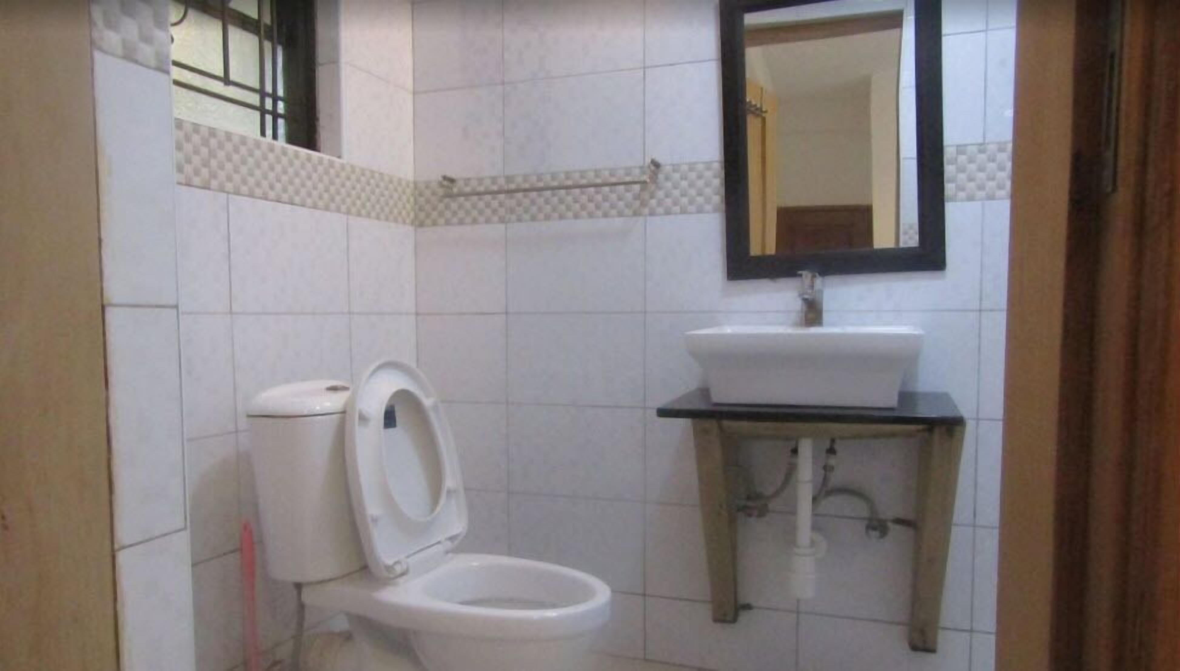 Un baño con inodoro, lavabo y espejo.