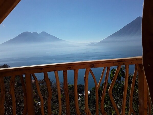 A wooden deck with a view of a lake and mountains. - El Picnic Atitlan (Santa Cruz La Laguna)