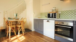 Une cuisine équipée d’une table à manger, de chaises, d’un four à micro-ondes, d’un lave-vaisselle et d’un four.