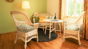 Une pièce chaleureuse avec des fauteuils en osier, une table ronde et un canapé agrémenté de coussins à motifs.