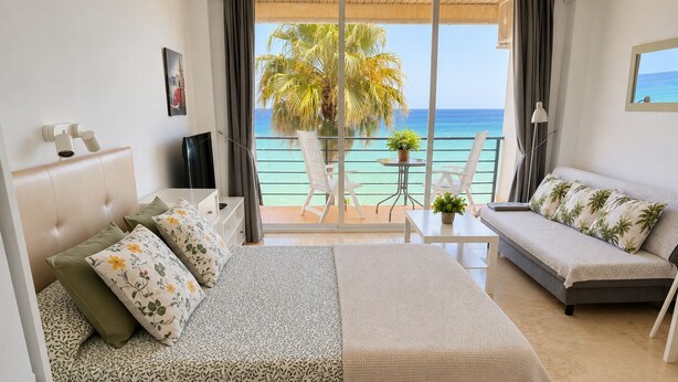 Ein Hotelzimmer mit Bett, Sofa, kleinem Tisch und Meerblick.