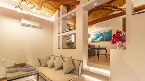A modern living room with a sofa, a dining table, and artwork on the walls.