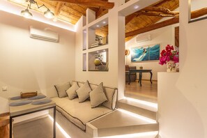 Suite superior, vista parcial al mar (Odysseus) | Área de sala de estar | Televisión LED de 37 pulgadas con canales digitales y televisión