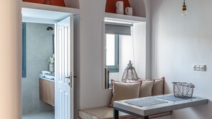 A hallway with a white door, a small table with a metal tray, and a mirror on the wall.
