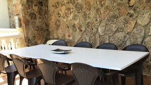A white rectangular table with six black chairs, set on a tiled floor with a diamond pattern. - El Magnolio Rural Cottage (Santa Cruz de Pinares, Ávila)