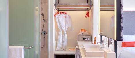A modern bathroom with a shower, a sink, and a mirror.
