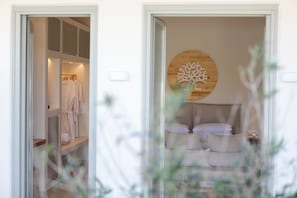 Relax in a serene space with a large bed and a unique headboard featuring a circular accent.