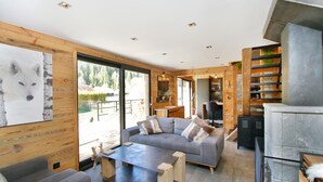 A modern interior with a grey sofa, wooden accents, and a large window.