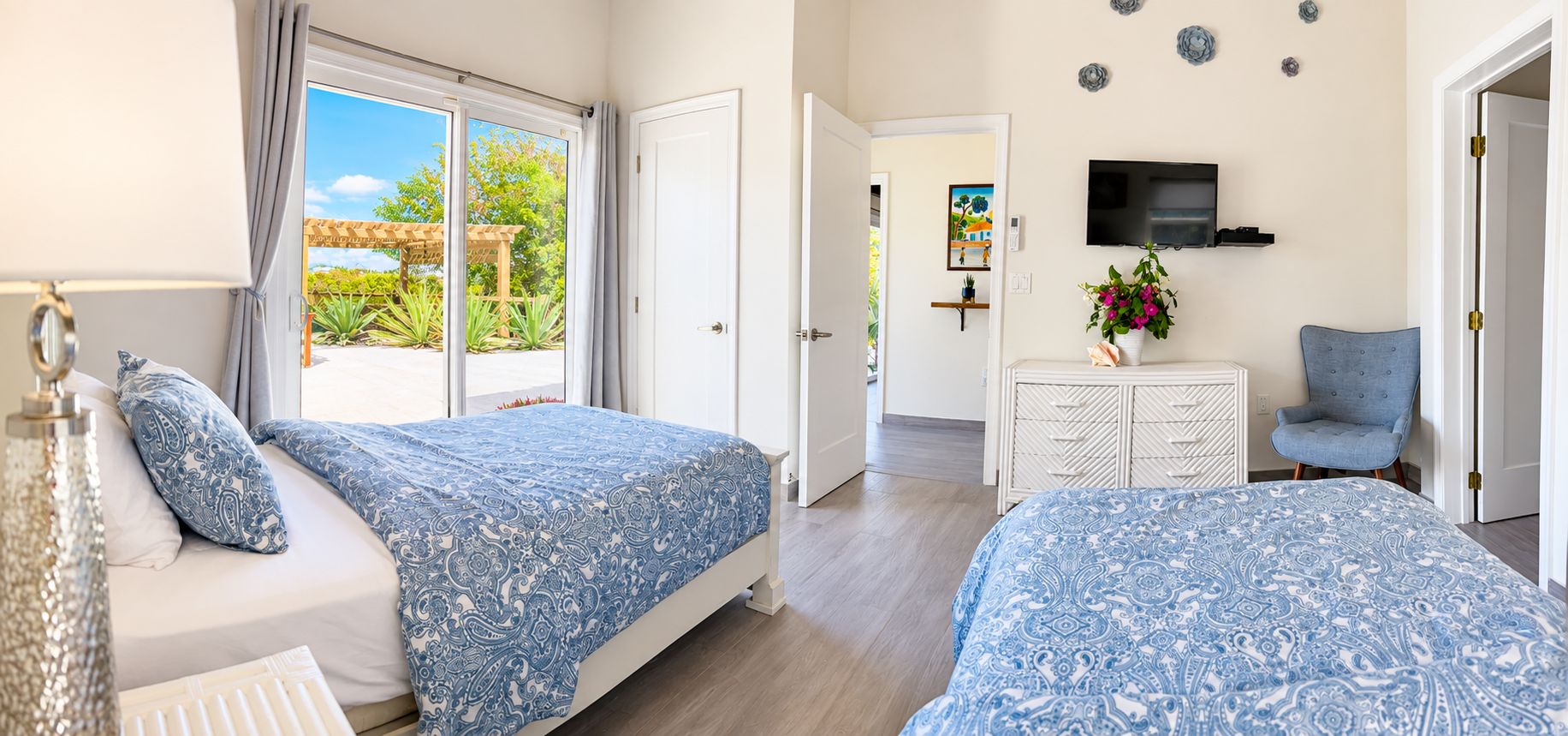 Quarto de hotel com duas camas, televisão, escrivaninha e uma cadeira.