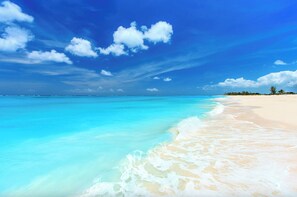 A beach with clear turquoise water and white sand.