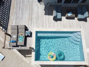 Una piscina sul tetto con sedie a sdraio e una vasca idromassaggio.