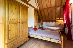 A bedroom with two wooden beds, a large wardrobe, and a red curtain. - 1Gite 12 pl. near Touquet with games room and SPA option 200 m (BEZINGHEM)