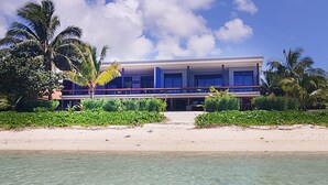 A beachfront hotel with a clear view of the ocean, a sandy beach, and palm trees. - Panama Beachfront Apartments Rarotonga (Rarotonga)