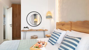Une chambre d’hôtel bien rangée, avec un lit, une table de chevet et un miroir.