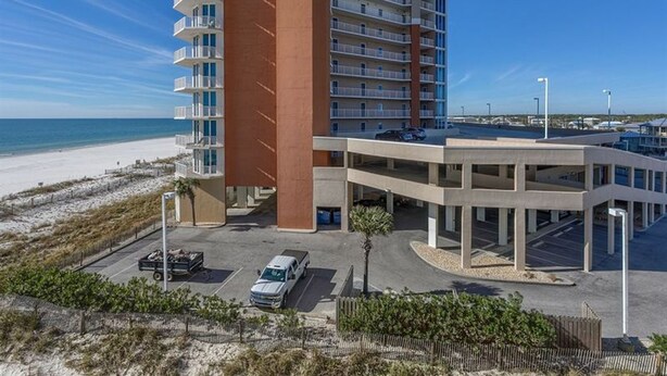 Un hôtel de grande hauteur doté de nombreux balcons, d’un parking souterrain et offrant une vue sur la plage.