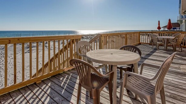 A wooden deck with a view of the beach and ocean. - Kokomo by Meyer Vacation Rentals (Gulf Shores)
