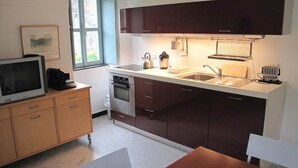 Una cocina compacta con horno integrado, un lavabo y un ventanal.