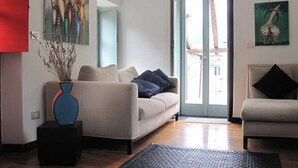 Una sala de estar con un sofá, una mesa de centro y un cuadro en la pared.