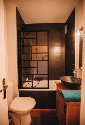 Een haardroger, handdoeken, zeep, toiletpapier