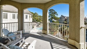A covered outdoor area with white chairs and a pool view. - Fantastic Pet Friendly Multi Family Home w/ Pool (Hilton Head Island)