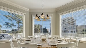 A dining area with a round table, white chairs, and a chandelier. - Fantastic Pet Friendly Multi Family Home w/ Pool (Hilton Head Island)