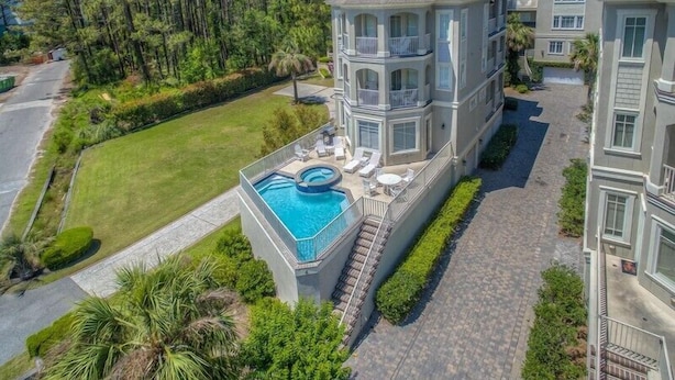 A multi-story residential building with a swimming pool and outdoor seating area. - Fantastic Pet Friendly Multi Family Home w/ Pool (Hilton Head Island)