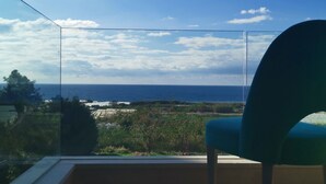 A balcony with a clear view of the sea and a chair. - Haya hotel & spa (Tabarja)