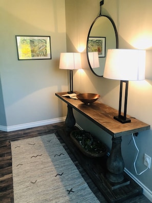 Enter a stylish space with a console table, mirror, and artwork.