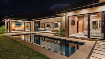 Una casa moderna con piscina, ventanas amplias y un interior luminoso.