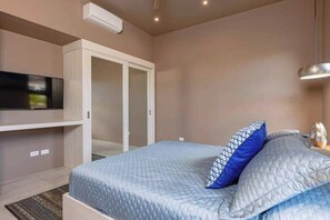 Un dormitorio con cama, televisor y armario.