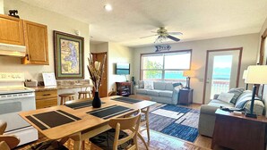 A spacious living area with a dining table, sofa, and a view of the outdoors. - Old Goat Inn, Wonderful Cottage on Flathead Lake (Somers)
