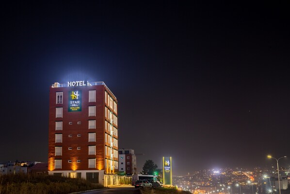A hotel building with a sign for "Star Hill Hotel & Spa" at night.