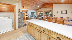 Una cocina amplia con armarios de madera, una isla grande y una pared decorativa de piedra.